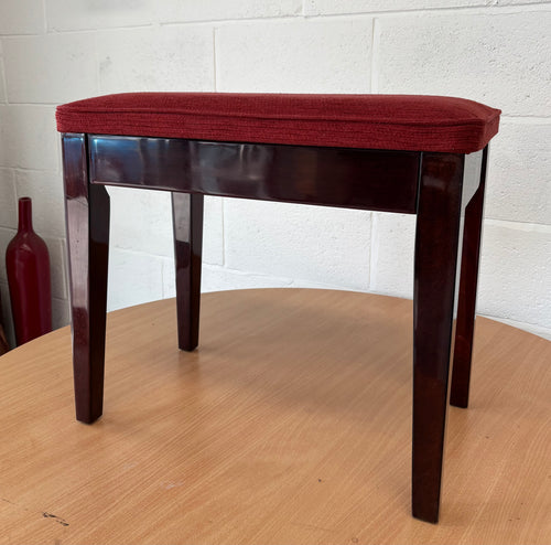 Polished black piano stool with red upholstered fabric top & storage