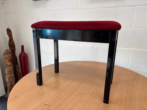 Polished black piano stool with red velour top & storage